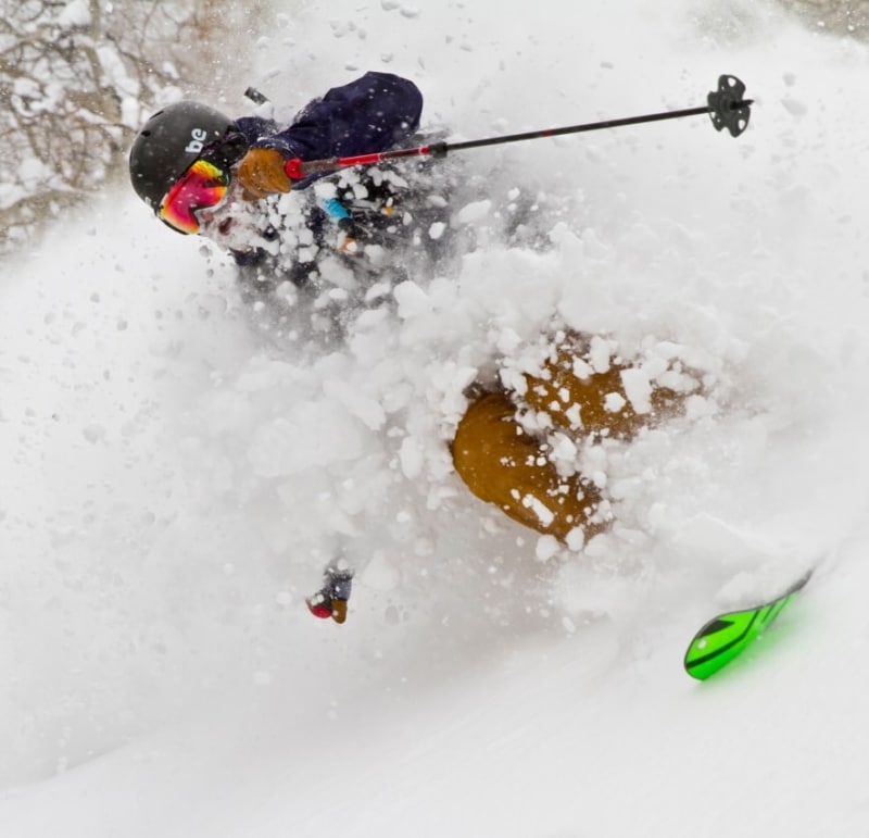 Skier skiing downhill through powdery snow